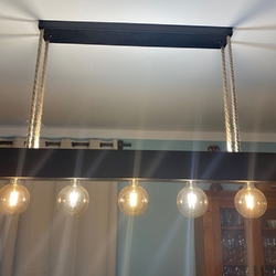 Schmiedeeiserner Designkronleuchter an Seilen aufgehängt – moderne Leuchte über dem Esstisch