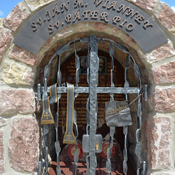 Schmiedeeisernes Denkmal der Heiligen mit Attributen auf dem Gitter. Stola und Brief mit der Aufschrift Buße