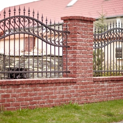 Schmiedeeiserner Zaun – moderne, schmiedeeiserne Umzäunung eines Einfamilienhauses
