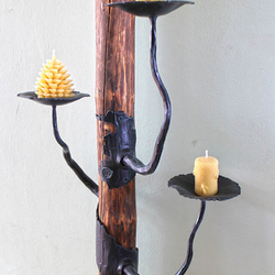 Schmiedeeiserner Kerzenhalter an einem Holzständer
