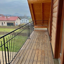 Exterior forged railing made for a wooden house