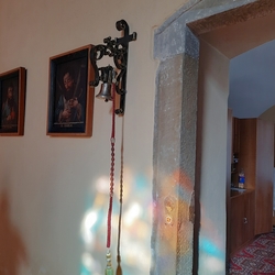 Geschmiedeter Glockenhalter bei der Tür in der Kirche